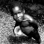 Petite fille mangeant du manioc. Guyane, Apatou