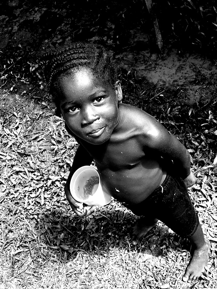 Petite fille mangeant du manioc. Guyane, Apatou